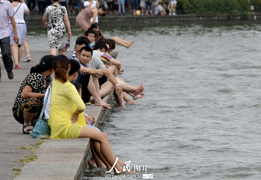 杭州西湖成了“洗腳池”。2013年7月21日,酷暑下的杭州猶如火爐一般,在白堤兩旁的西湖邊,一些不自覺的游客,脫去了鞋襪把腳浸入湖中,享受湖水帶來的涼爽。遠遠望去,美麗的西胡竟然成了天然的“洗腳池”,真是大煞風景。7月21日,一群游客坐在西湖邊洗腳納涼。施健學/人民圖片
