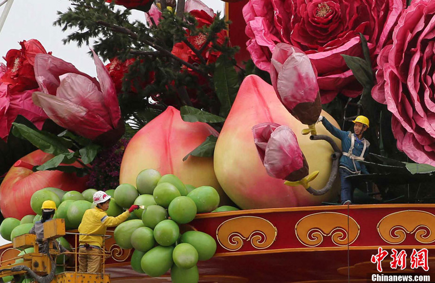9月23日,工作人员在对“花果篮”做最后的调整。当日,北京天安门广场“祝福祖国”花坛主景“花果篮”完成主体结构安装。据了解,2013年国庆花篮高达18.2米,篮盘直径达到15米,中心花坛直径达到50米,是天安门广场历年最大的花篮。中新社发 韩海丹 摄