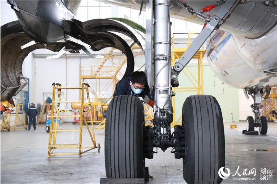 袁蒙正在檢查飛機的起落架。人民網 李芳森攝